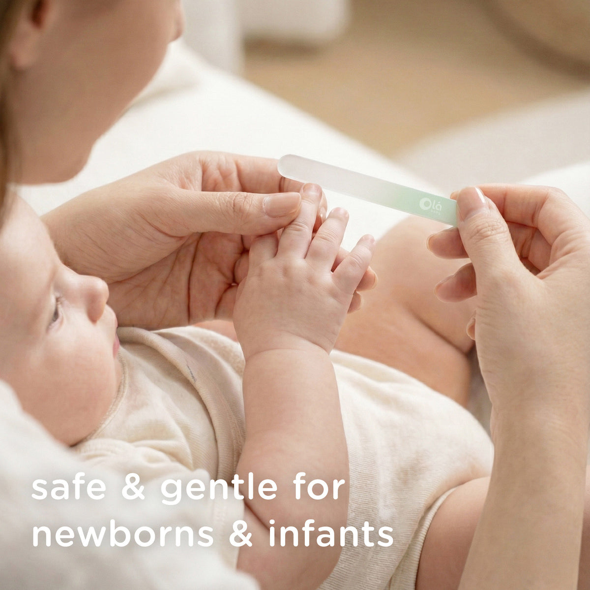 A mother gently filing her newborn baby's tiny fingernails using a safe and gentle Olababy glass nail file.