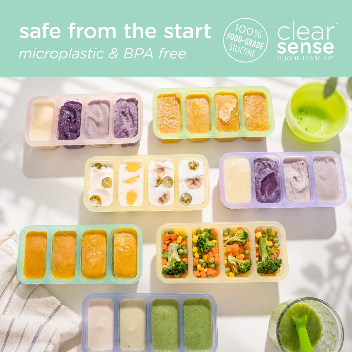 An overhead flat-lay of colorful Olababy silicone baby food storage trays filled with healthy purees, highlighting that they are microplastic and BPA-free